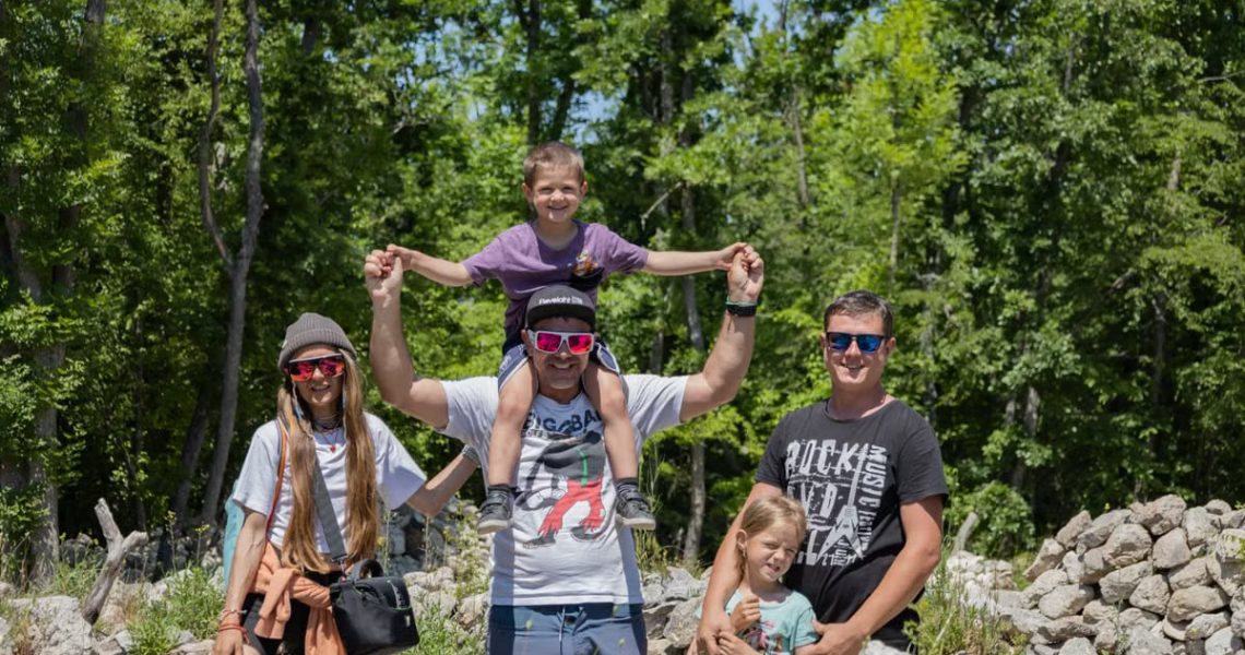 A joyful family enjoying a sunny day outdoors, captured in a lively and happy moment.